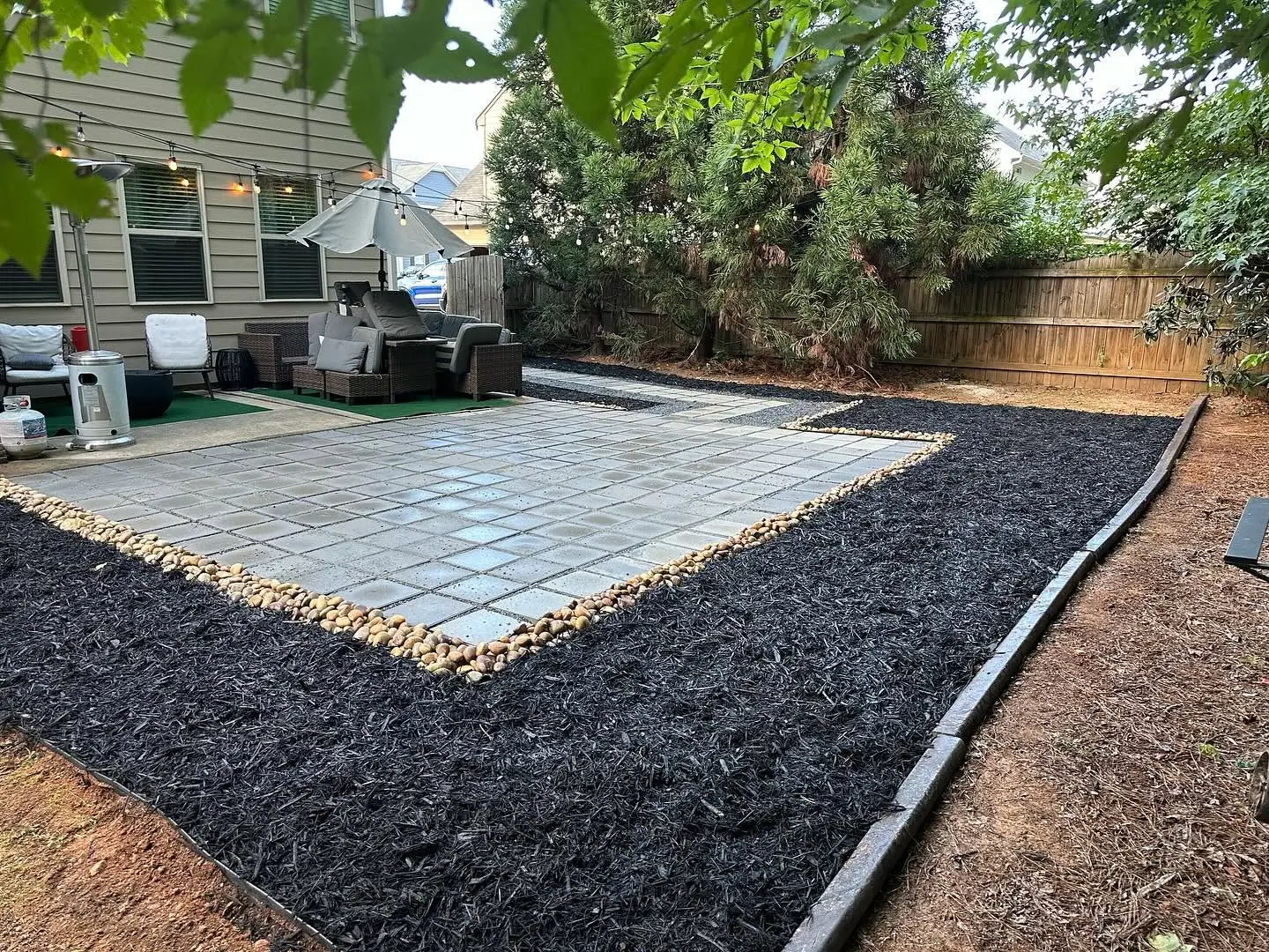 Newly mulched patio bed with river rock border at a Marietta, GA home