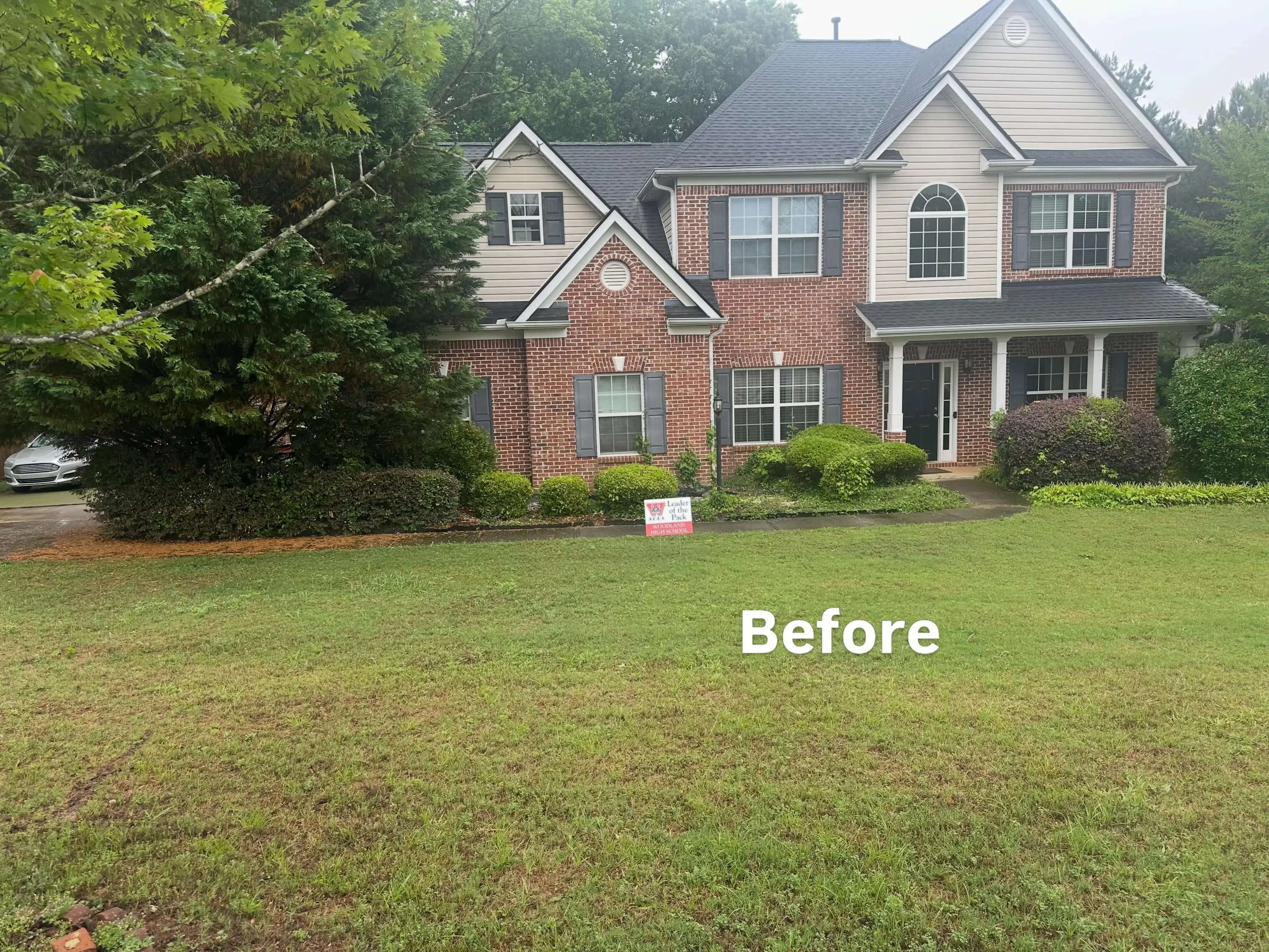 Overgrown Marietta, GA front lawn before a D.G. Property Management mowing and cleanup visit