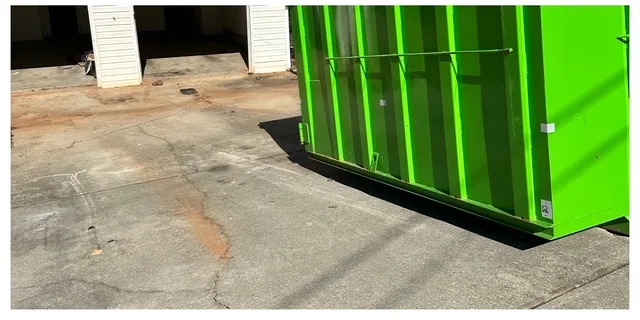 Cleared garage and driveway with roll-off dumpster staged after a Marietta, GA junk removal