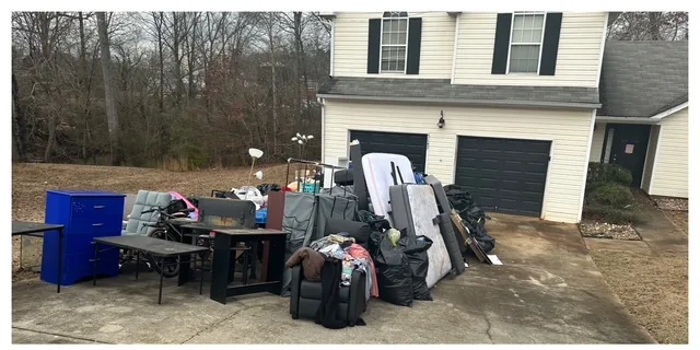 Furniture, mattress, and household junk piled at the curb before a Marietta, GA haul-away